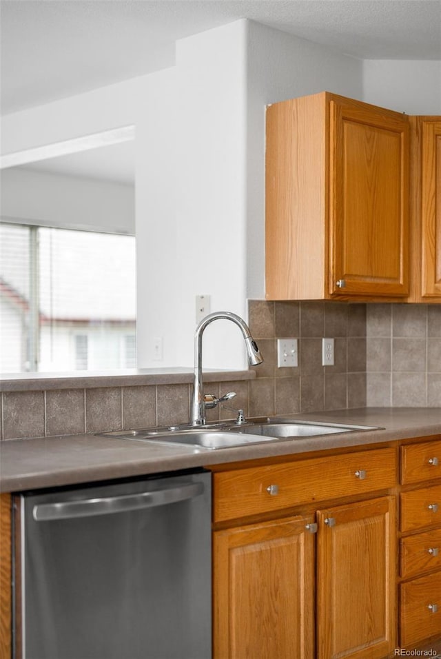 6193 Terry Ct, Arvada, CO 80403 - kitchen with stainless steel dishwasher, a sink, tasteful backsplash, and brown cabinetry