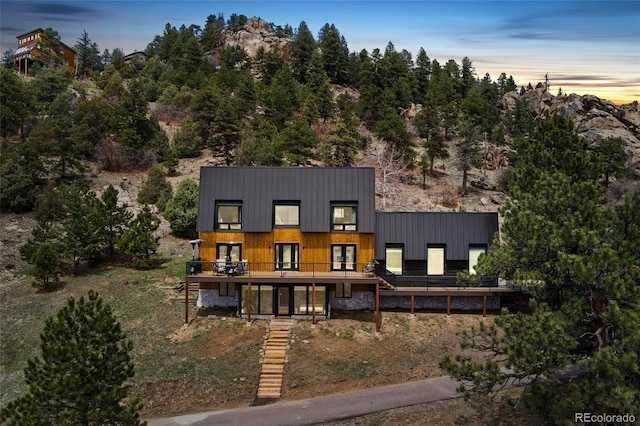 6640 Kilimanjaro Dr, Evergreen, CO 80439 - contemporary home with french doors, a standing seam roof, and a deck
