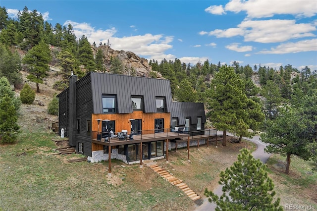 6640 Kilimanjaro Dr, Evergreen, CO 80439 - back of property with a wooden deck, metal roof, and a standing seam roof