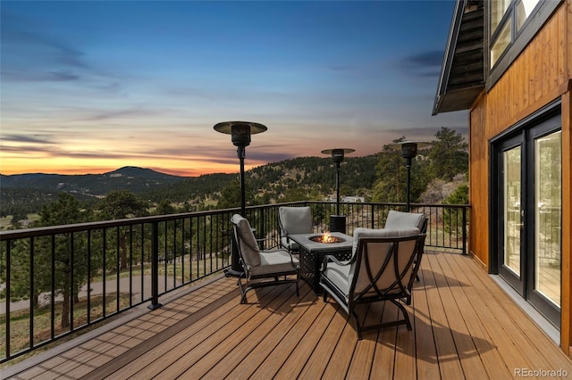 6640 Kilimanjaro Dr, Evergreen, CO 80439 - deck at dusk featuring a mountain view and an outdoor fire pit
