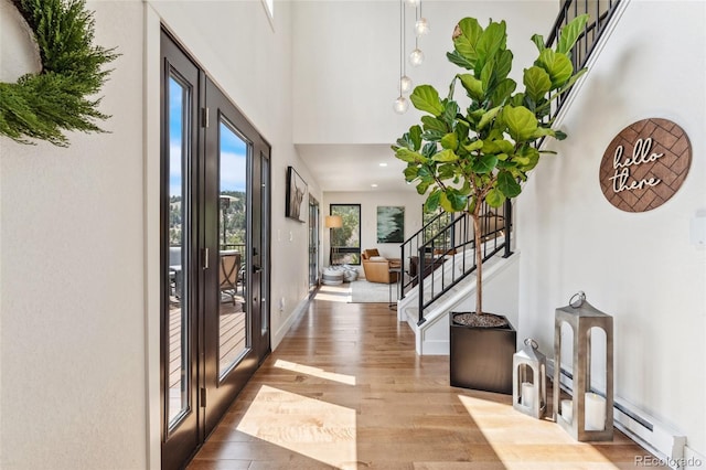 6640 Kilimanjaro Dr, Evergreen, CO 80439 - entrance foyer featuring a towering ceiling, wood finished floors, stairway, baseboards, and a baseboard radiator