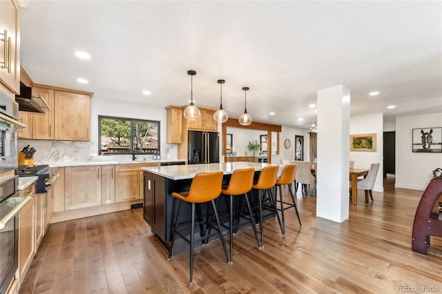 6640 Kilimanjaro Dr, Evergreen, CO 80439 - kitchen with stainless steel appliances, a center island, hardwood / wood-style floors, and light brown cabinets