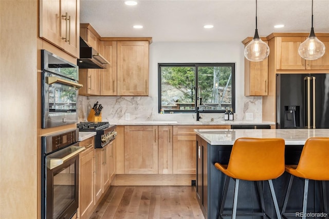 6640 Kilimanjaro Dr, Evergreen, CO 80439 - kitchen featuring light brown cabinetry, stainless steel appliances, hardwood / wood-style flooring, and wall chimney exhaust hood