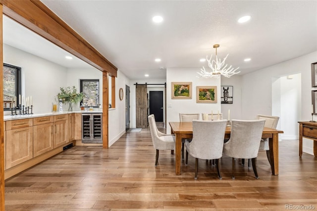 6640 Kilimanjaro Dr, Evergreen, CO 80439 - dining area featuring a barn door, light wood-style floors, recessed lighting, and beverage cooler