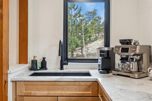 6640 Kilimanjaro Dr, Evergreen, CO 80439 - details featuring light stone counters, a sink, and a textured wall