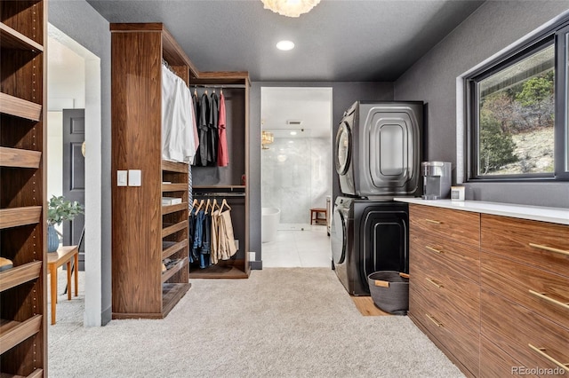 6640 Kilimanjaro Dr, Evergreen, CO 80439 - walk in closet featuring visible vents, stacked washer and clothes dryer, and light colored carpet