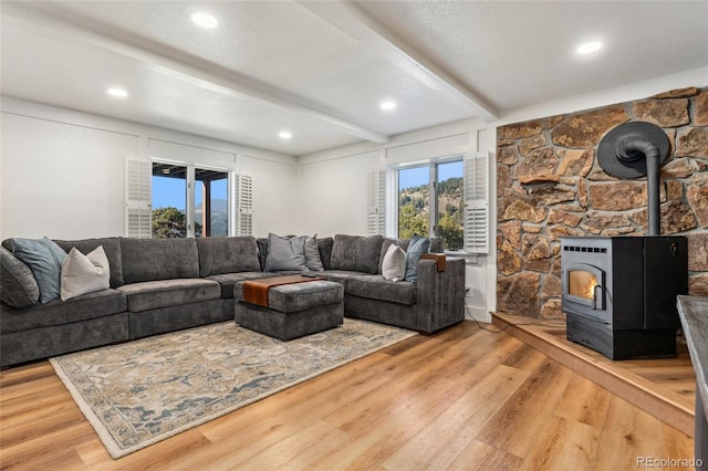 6640 Kilimanjaro Dr, Evergreen, CO 80439 - living room featuring recessed lighting, a wood stove, light wood-type flooring, and beam ceiling