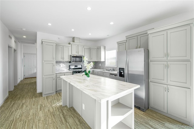 6 Timberlake Ct, Byers, CO 80103 - kitchen featuring stainless steel appliances, open shelves, a kitchen island, backsplash, and light wood-style flooring