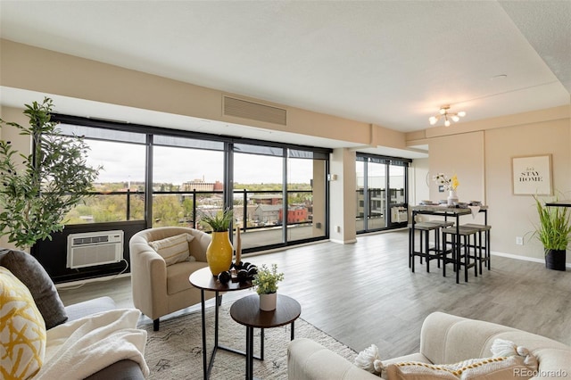 living room featuring light wood-type flooring and an AC wall unit