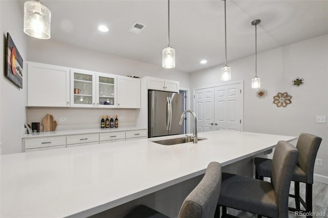 171 S Waterloo St, Aurora, CO 80018 - kitchen with freestanding refrigerator, a kitchen bar, white cabinetry, pendant lighting, and recessed lighting