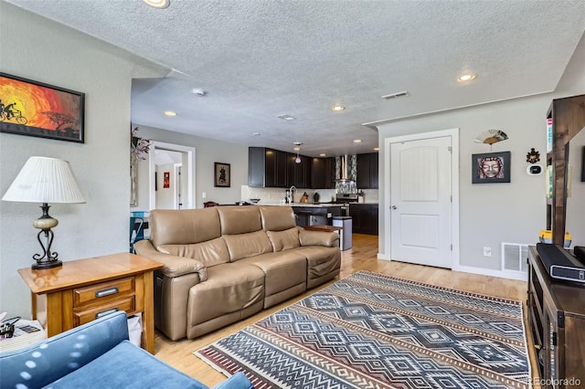 2901 N Glencoe St, Denver, CO 80207 - living room with a textured ceiling, light wood-type flooring, and recessed lighting