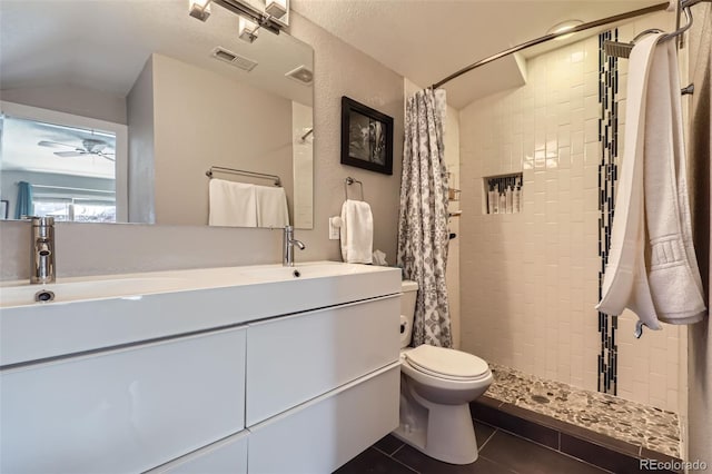 2901 N Glencoe St, Denver, CO 80207 - bathroom featuring vaulted ceiling, double vanity, a tile shower, tile patterned flooring, and toilet