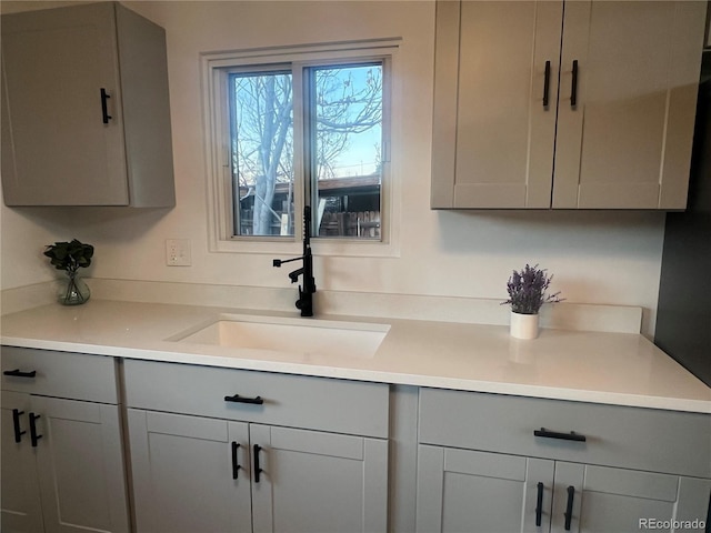 kitchen featuring gray cabinets and sink