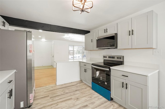 kitchen with appliances with stainless steel finishes, beamed ceiling, a notable chandelier, white cabinets, and light hardwood / wood-style floors