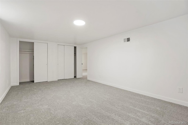 unfurnished bedroom featuring carpet and multiple closets