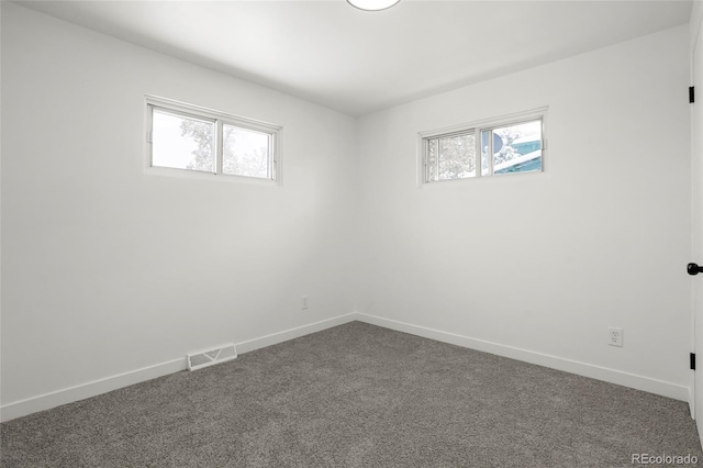 unfurnished room with dark carpet