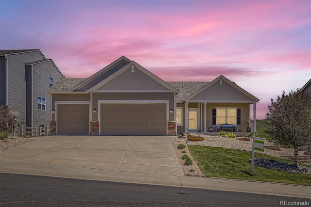 craftsman-style house with a garage, a yard, driveway, and stucco siding