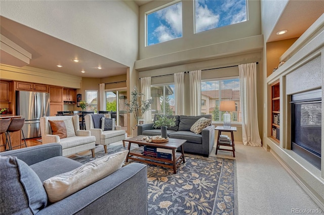 9952 Pinedale Dr, Colorado Springs, CO 80920 - living room with a towering ceiling, light carpet, built in shelves, recessed lighting, and baseboards