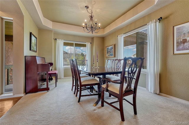 9952 Pinedale Dr, Colorado Springs, CO 80920 - dining area with a chandelier, a textured wall, light carpet, baseboards, and a tray ceiling