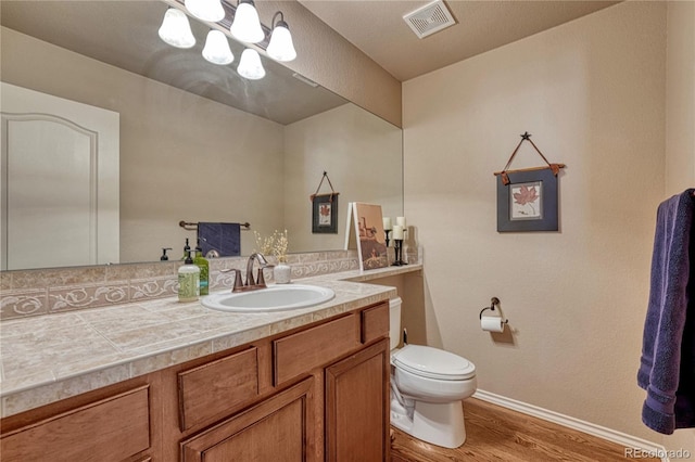 9952 Pinedale Dr, Colorado Springs, CO 80920 - bathroom featuring wood finished floors, toilet, baseboards, vanity, and a chandelier