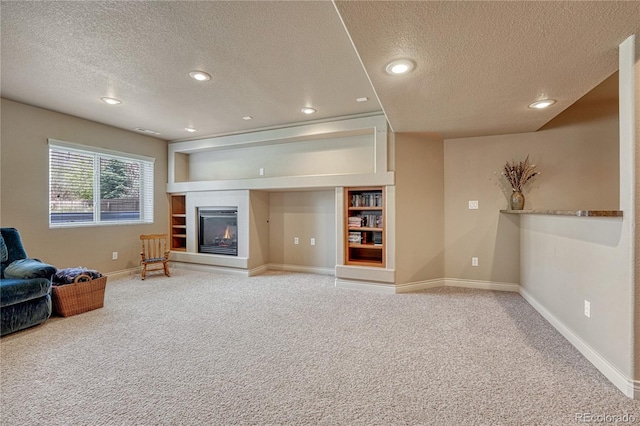 9952 Pinedale Dr, Colorado Springs, CO 80920 - carpeted living area featuring a textured ceiling, baseboards, a glass covered fireplace, recessed lighting, and built in features