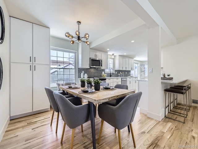 dining space with sink, a wealth of natural light, and light hardwood / wood-style floors