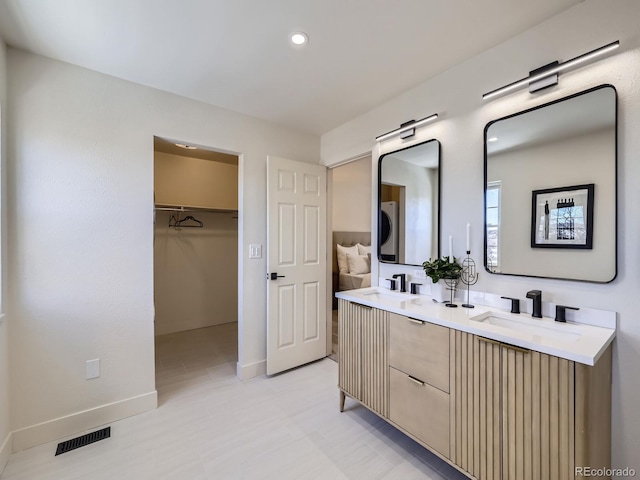 bathroom with vanity and stacked washer / drying machine