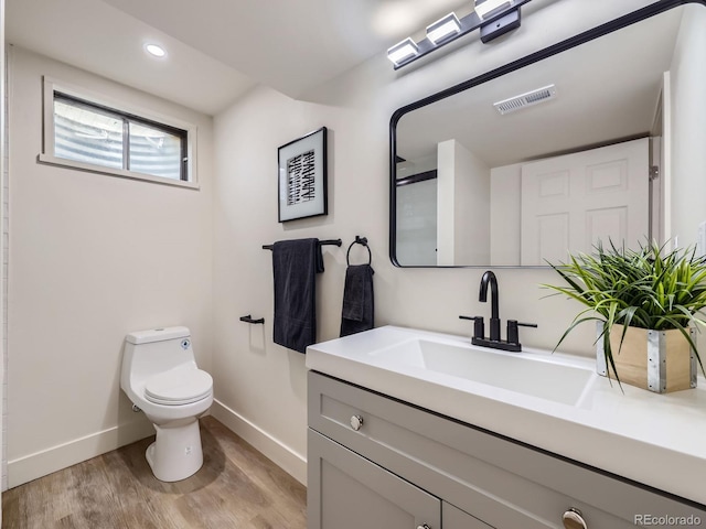 bathroom with vanity, hardwood / wood-style floors, and toilet