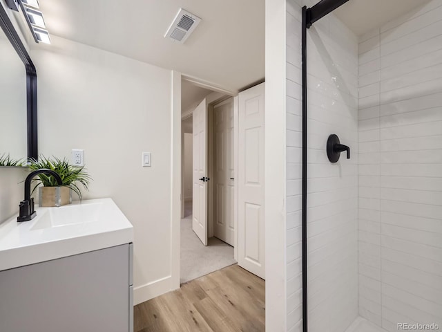 bathroom featuring vanity, hardwood / wood-style floors, and walk in shower