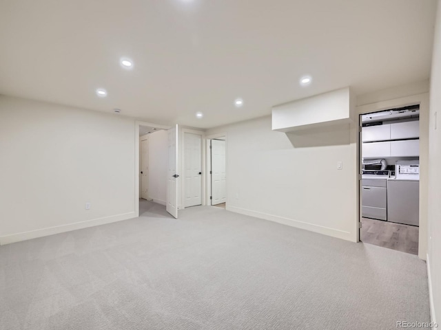 spare room with light colored carpet and washer and dryer