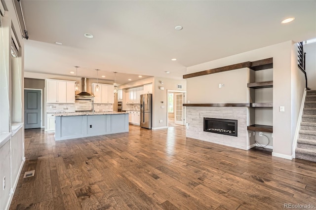 15437 W 95th Ave, Arvada, CO 80007 - unfurnished living room featuring stairway, dark wood-style flooring, recessed lighting, and a glass covered fireplace