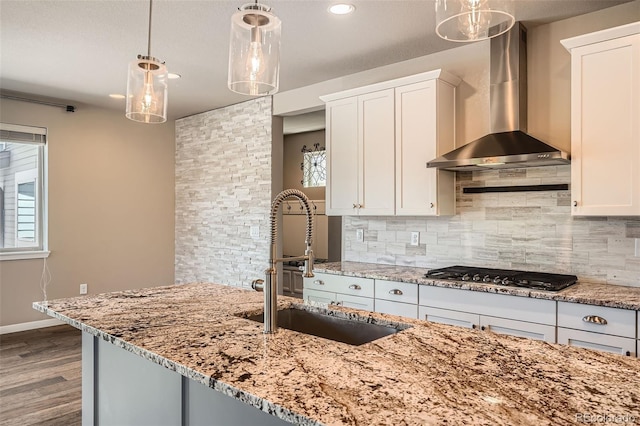 15437 W 95th Ave, Arvada, CO 80007 - kitchen featuring wall chimney range hood, stainless steel gas cooktop, tasteful backsplash, light stone counters, and recessed lighting