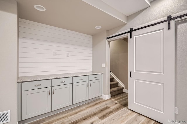 15437 W 95th Ave, Arvada, CO 80007 - hallway featuring a barn door and light wood-style floors