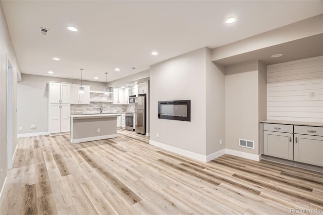 15437 W 95th Ave, Arvada, CO 80007 - kitchen featuring stainless steel appliances, light countertops, tasteful backsplash, light wood-type flooring, and recessed lighting