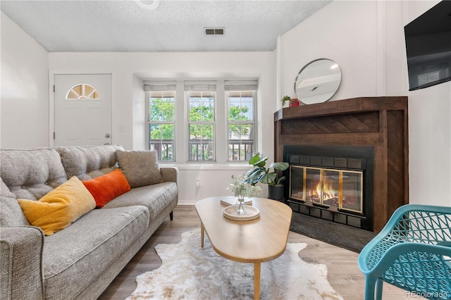 3050 W 107th Pl Unit E, Westminster, CO 80031 - living room featuring wood finished floors, a fireplace with flush hearth, and a textured ceiling