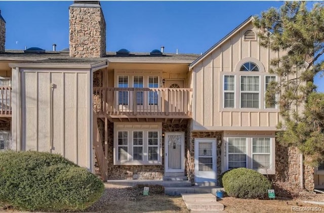 3050 W 107th Pl Unit E, Westminster, CO 80031 - back of property with a balcony, a chimney, board and batten siding, and stone siding