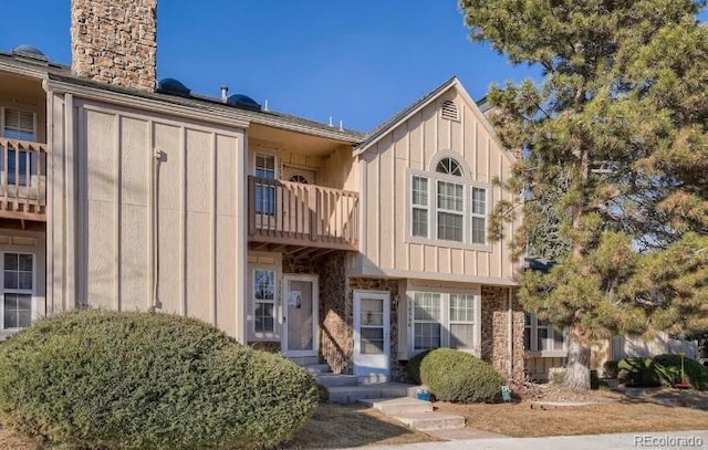 3050 W 107th Pl Unit E, Westminster, CO 80031 - view of front of home with board and batten siding, a balcony, and a chimney