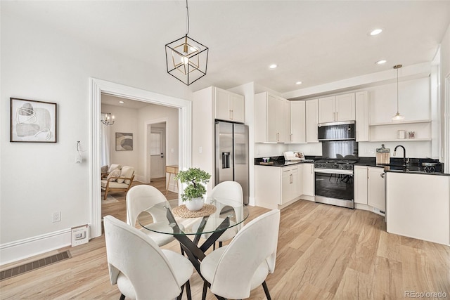 dining area featuring light wood-style flooring, recessed lighting, baseboards, and a chandelier