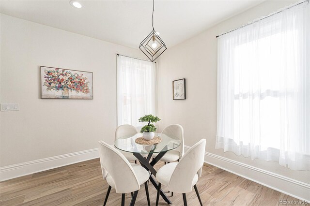 dining room with light wood finished floors, baseboards, and a healthy amount of sunlight