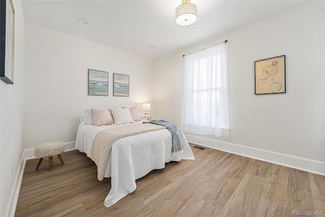 bedroom with light wood-style floors and baseboards