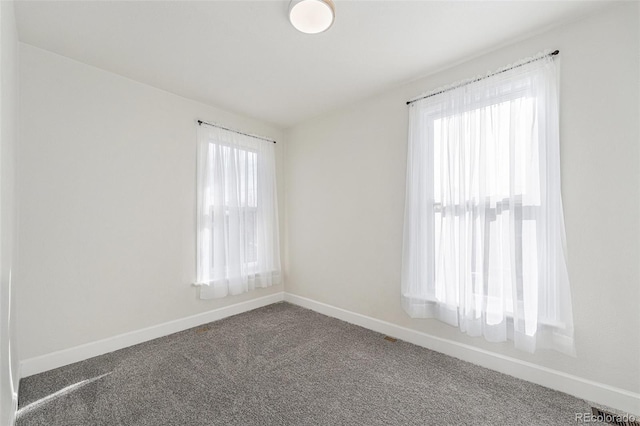carpeted empty room with baseboards