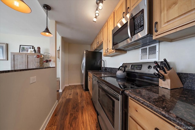 kitchen featuring appliances with stainless steel finishes, dark hardwood / wood-style flooring, light brown cabinetry, sink, and hanging light fixtures