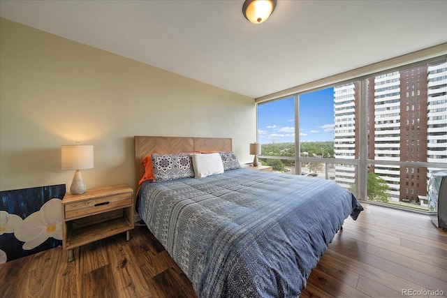 bedroom with expansive windows and dark wood-type flooring