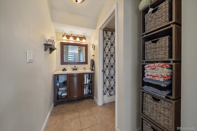 bathroom with walk in shower, sink, and tile patterned flooring