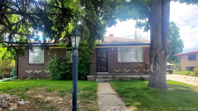 view of front of property featuring a front yard and brick siding