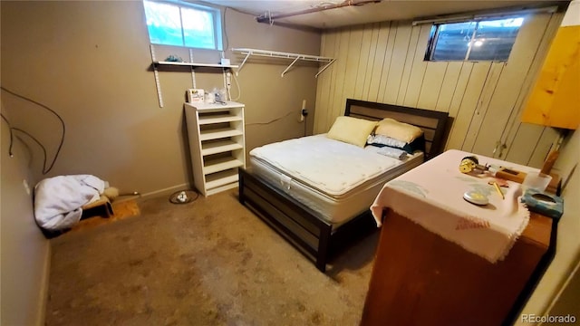 carpeted bedroom featuring wooden walls