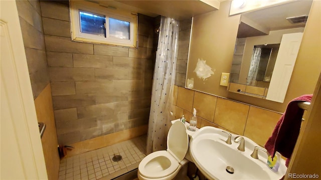 full bathroom with toilet, a sink, visible vents, tile walls, and a stall shower