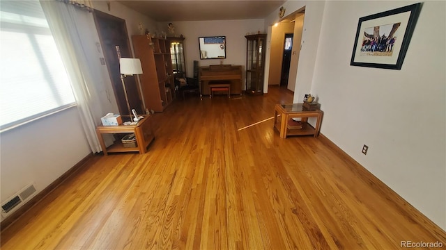 hallway featuring wood finished floors and visible vents