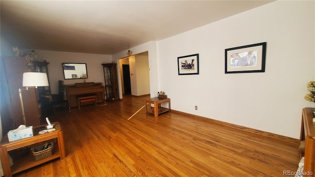 living area featuring baseboards and wood finished floors