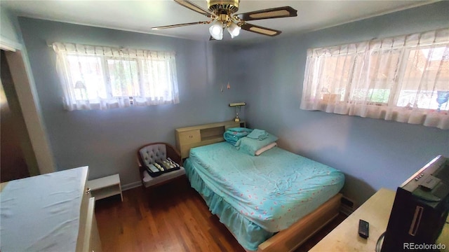 bedroom with ceiling fan, baseboards, and wood finished floors